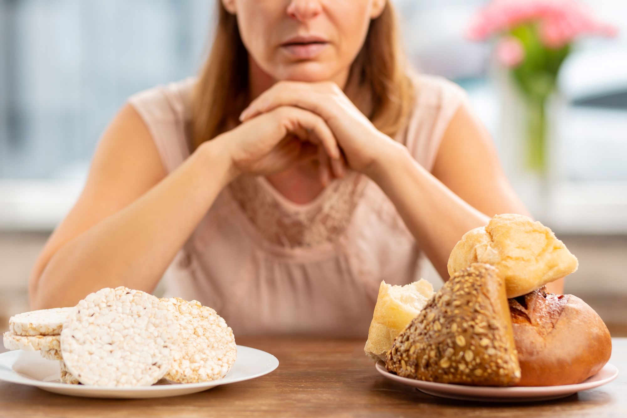 woman choosing between bread and gluten-free food