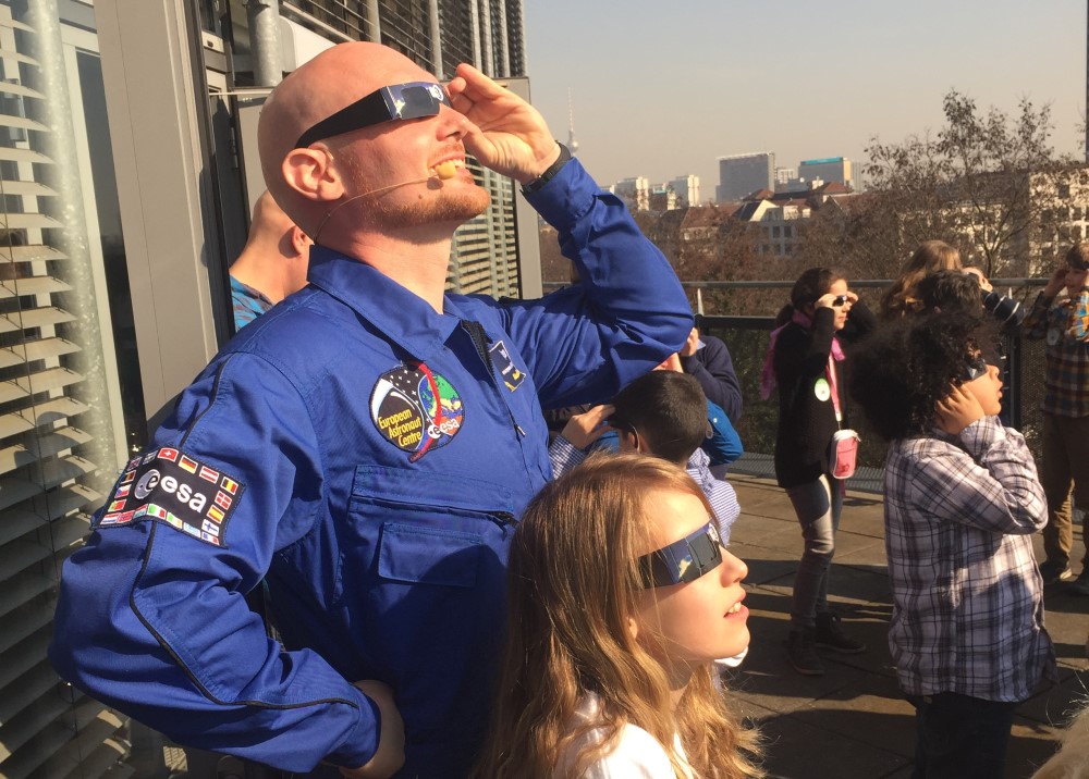 El astronauta de la ESA Alexander Gerst y un grupo de niñas y niños observan un eclipse solar en Berlín