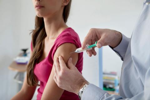 Woman receiving a vaccine in her arm.