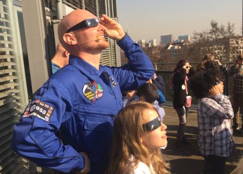 ESA astronaut Alexander Gerst and a group of boys and girls observe a solar eclipse in Berlin.