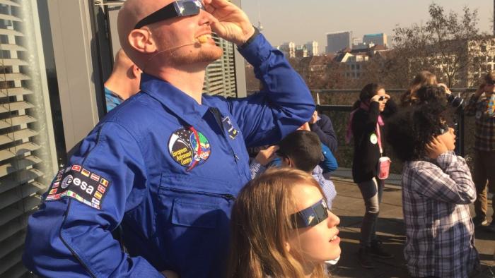 El astronauta de la ESA Alexander Gerst y un grupo de niñas y niños observan un eclipse solar en Berlín